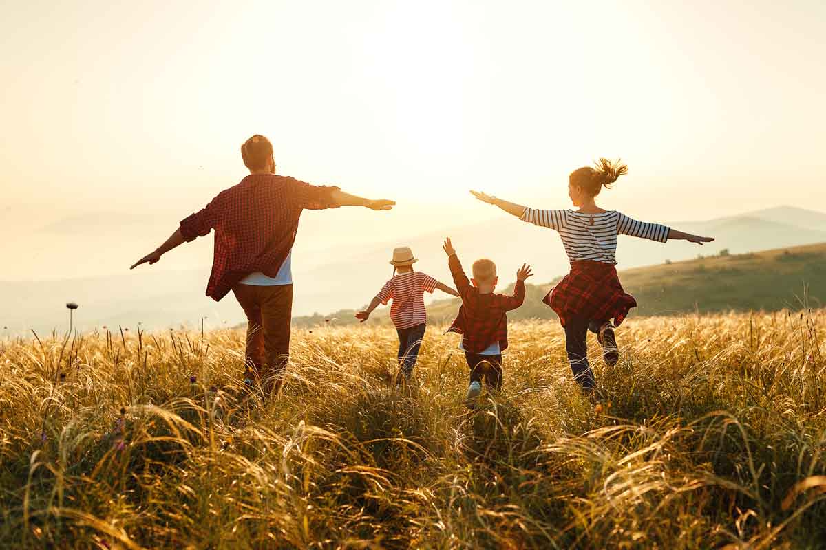 Happy family: mother, father, children son and daughter on nature on sunset