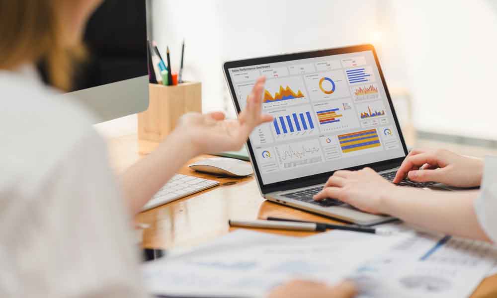 Two accountants using KPI dashboard for data analytics. Digital data technology concept is on a laptop.