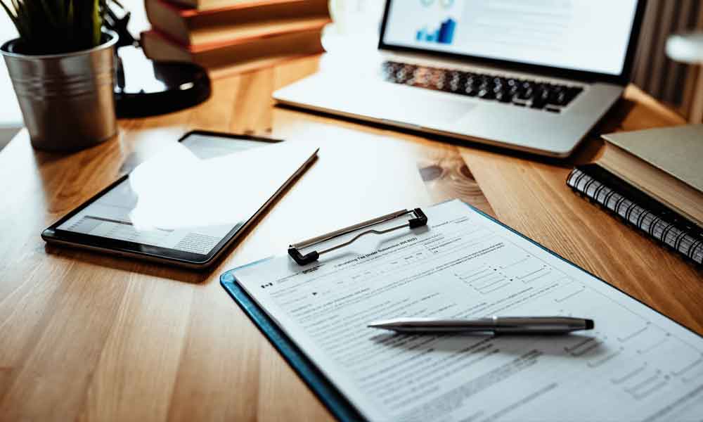 Canadian Taxes Desk with tablet, laptop and a Canadian Tax form on it for accounting.